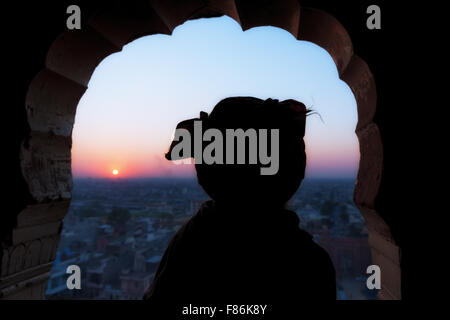 Silhouette of a Sadhu watching the sunset over Jaipur,  Galtaji, Khania-Balaji, Jaipur, Rajasthan, India Stock Photo