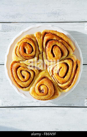 baked cinnamon buns on white plate, food top view Stock Photo