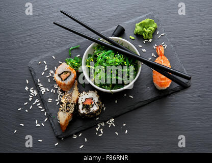 Sushi and seaweed salad on slate table Stock Photo