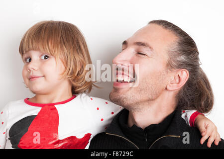 Smiling Young man with little blond Caucasian girl, studio portrait over white wall background Stock Photo