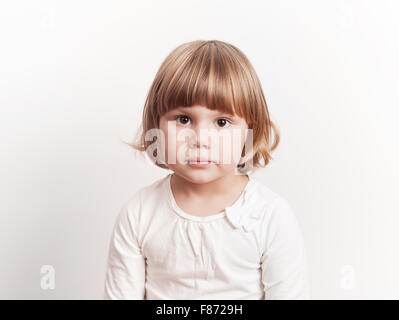 Cute little blond Caucasian girl over white background, studio portrait Stock Photo