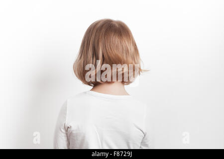 Little blond Caucasian girl back over white background, studio portrait Stock Photo