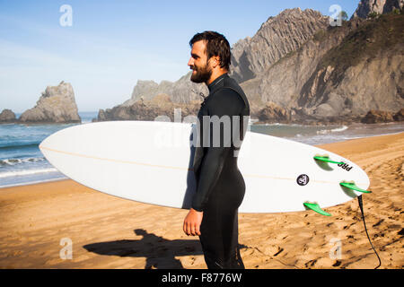 surfer with his board on the beach watching the sea Stock Photo