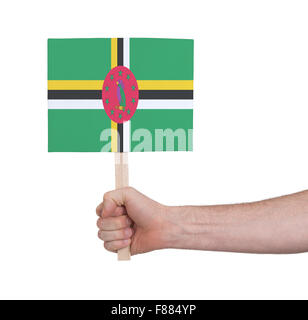 Hand holding small card, isolated white - Flag of Dominica Stock Photo