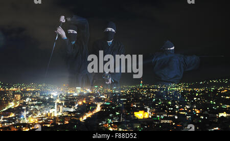 ninja assasin hold katana samurai old martial weapon swordat night with city lights in background Stock Photo