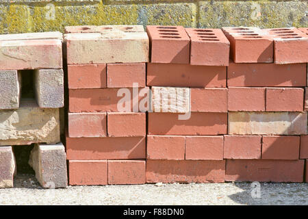 Stack of new and old red house bricks Stock Photo