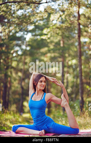 Healthy girl doing yoga exercises on fresh air Stock Photo