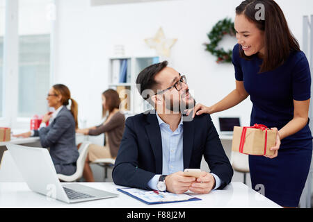 Asian businesswoman giving her boss Christmas present in office Stock Photo