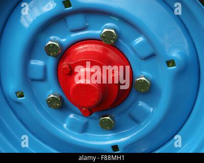 detail of blue classic tractor wheel with silver bolts and red boss /hub  in bright sunshine Stock Photo