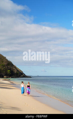 Women walking on beach at Octopus Resort, Waya Island, Yasawa Islands, Fiji (MR) Stock Photo