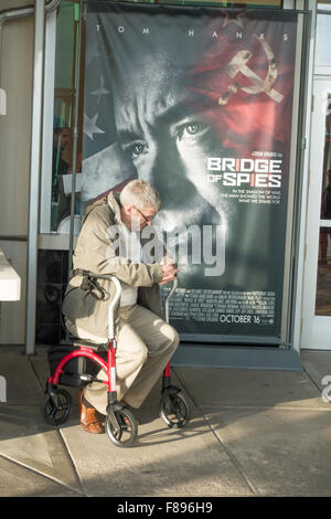 Senior gentleman waiting in his walker at the theater in front of a Bridge of Spies poster. Roseville Minnesota MN USA Stock Photo