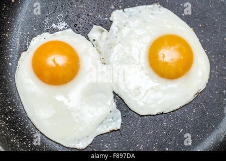 Fried eggs in the frying pan. Stock Photo