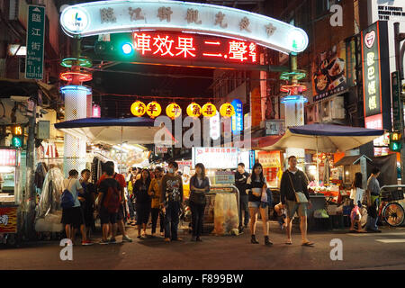 Entrance to Linjiang Street (Tonghua) Night Market in Taipei with pedestrians crossing the road Stock Photo