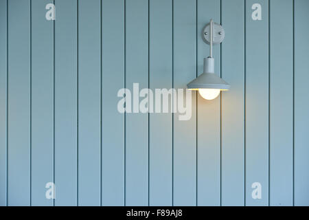 wall made from wood panel painted blue and white lamp on the wall Stock Photo