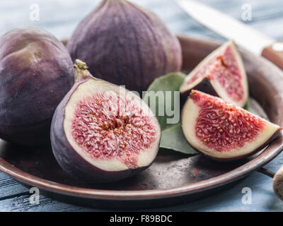 Ripe fig fruits on in the old tray on the wooden table. Stock Photo