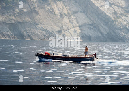 Monterosso, Italy - 7 July 2015: Man navigating his boat near Monterosso on Cinque Terre, Italy Stock Photo