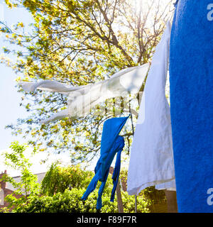 Clothes drying on a washing line in a garden, England, UK Stock Photo