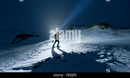 Snowshoe hiker at night with headlamp, Iceland Stock Photo