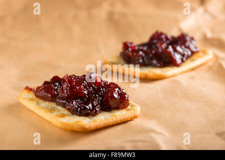 Quince jam on saltine crackers on paper Stock Photo