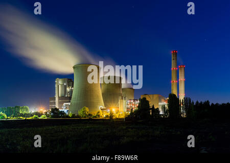 A large coal-fired power plant at night with a lot of steam and deep blue sky. Stock Photo
