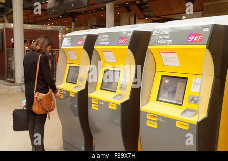 A woman buying a train rail ticket at a ticket machine, Gare du Nord, Paris France Europe Stock Photo