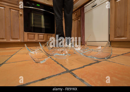 remnants pile of broken glass on floor after accident and pyrex glass bowl slipped out of wet hands knocked over landed on floor Stock Photo