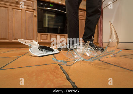 remnants pile of broken glass on floor after accident and pyrex glass bowl slipped out of wet hands knocked over landed on floor Stock Photo