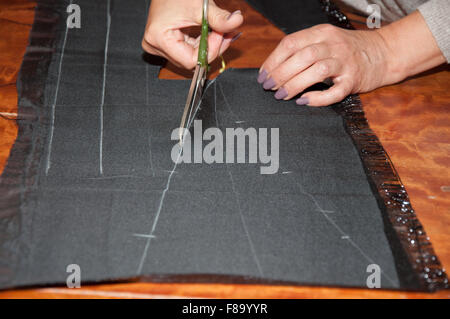 dressmaker at work making patterns of fabric Stock Photo