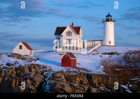 Snow surrounds Nubble (Cape Neddick) lighthouse lit up for the holiday season on New Year's Eve in Maine. Stock Photo