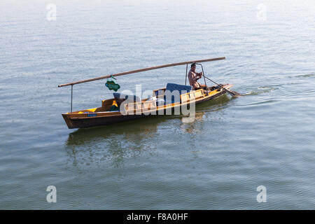 Hangzhou, China - December 5, 2014: Traditional Chinese wooden recreation boat with boatman on West Lake. Famous park Stock Photo