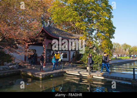 Hangzhou, China - December 5, 2014: traditional Chinese wooden gazebo on the West Lake coast. Ordinary people walking Stock Photo