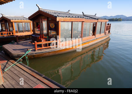 Hangzhou, China - December 5, 2014: Traditional Chinese wooden boat with passengers on the West Lake, famous park in Hangzhou Stock Photo
