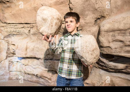 Strong child holds heavy stones. Stock Photo