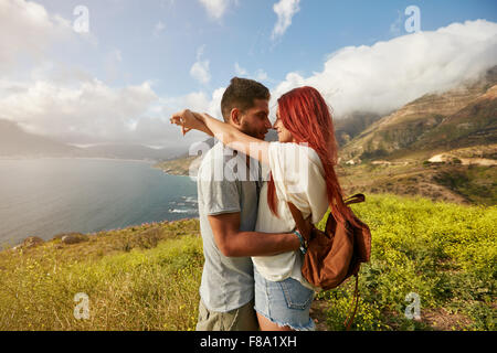 Side view of romantic young couple on holidays. Man and woman embracing each other outdoors. Stock Photo