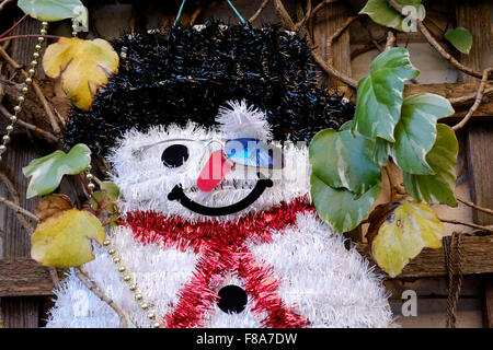 snowman christmas decoration hanging on garden trellis Stock Photo