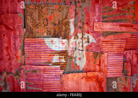 An abstract background image of the flag of Hong Kong painted on to rusty corrugated iron sheets overlapping to form a wall Stock Photo