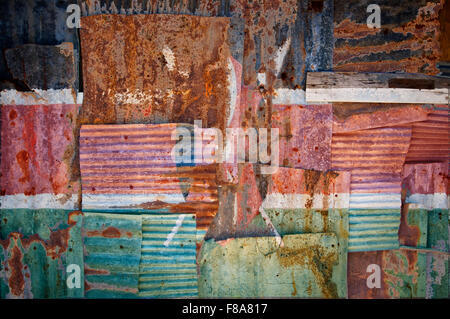 An abstract background image of the flag of Kenya painted on to rusty corrugated iron sheets overlapping to form a wall or fence Stock Photo