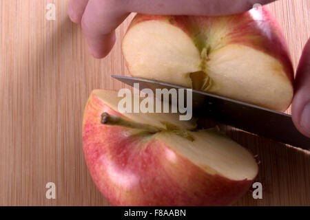 apple cut in half with knife Stock Photo