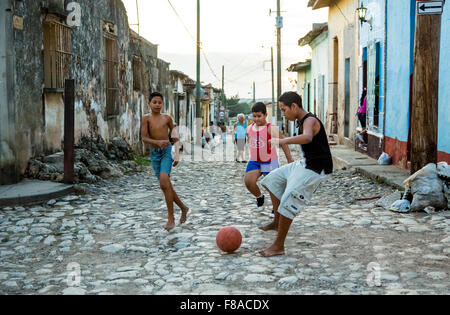 Kids playing soccer in the street of Trinidad, stone pavement, poverty, fun, paving stones, Trinidad, Cuba, Sancti Spíritus, Stock Photo