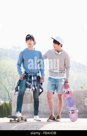 Two men with their skateboards standing next to each other Stock Photo