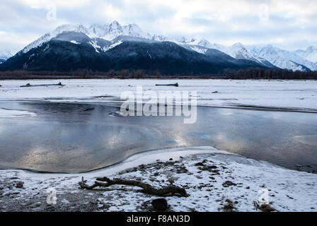 Sunset colors reflected in ice and water on the Chilkat river in Southeast Alaska in winter. Stock Photo