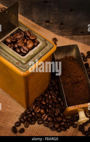 Old coffee mill with coffee beans on a bag Stock Photo