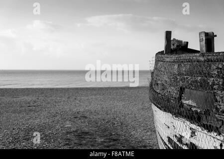 Old abandoned fishing boat on beach in black and white Stock Photo