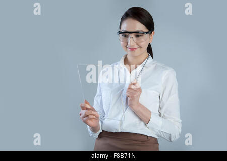 Business woman holding touch screen and wearing goggles Stock Photo