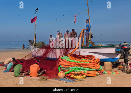 Fishermen tending their nets Colva Beach Goa India Stock Photo