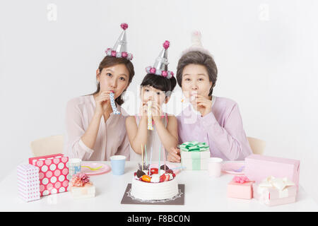 Mother, daughter, and granddaughter celebrating birthday together Stock Photo