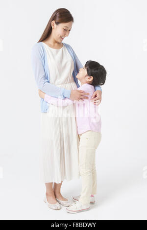 Mother and daughter standing and hugging each other and looking at each other Stock Photo