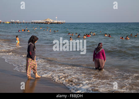 Turkish women bathing in the sea, with clothes, Side-Sorgun, Side Belediyesi, Turkish Riviera, Antalya, Turkey Stock Photo