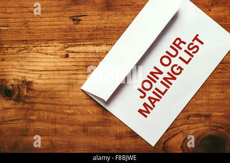 Join our mailing list imprint stamp on white paper envelope placed on top of office desk, top view Stock Photo