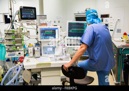 Surgical monitors being used to track the vital signs of a patient during an operation. Stock Photo